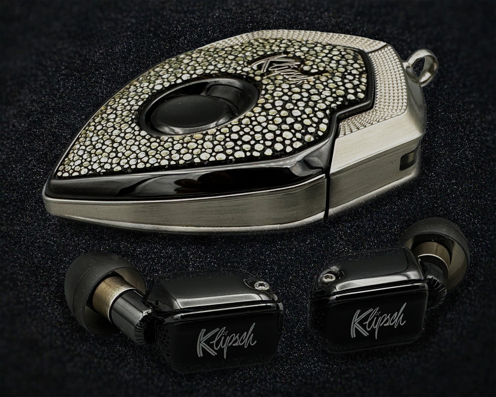 Disco Inferno charging case with silver stingray cover beside two black earbuds