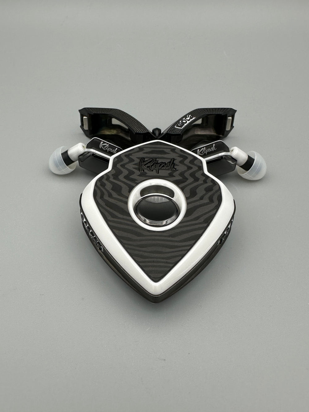 MoCA Phantom black and white charging case with doors open and earbuds tucked beside it