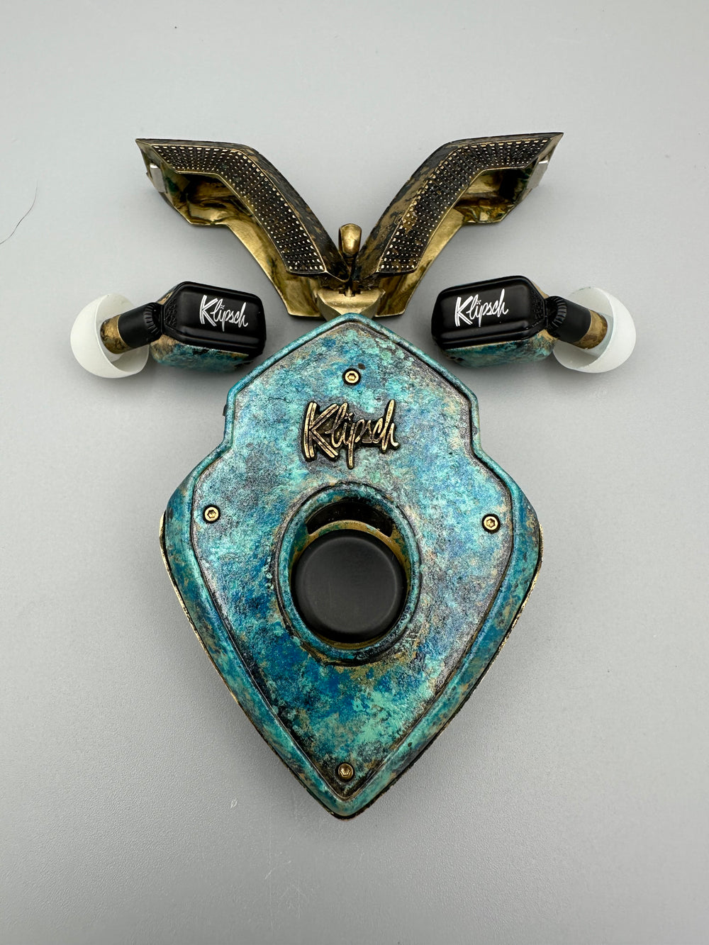 20,000 Leagues Under the Sea teal patina charging case with brass doors open and earbuds