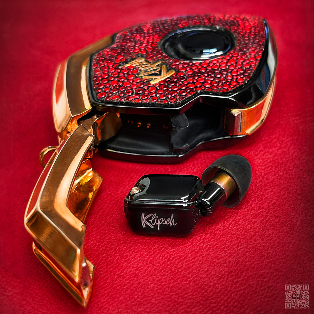 Ruby in the Rough charging case open with gold door swung out and one black earbud